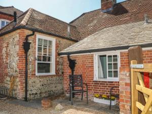 a red brick house with a black chair in front of it at The Old School House in Chichester