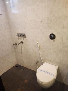 a bathroom with a white toilet in a stall at Hotel Ikon in Hubli