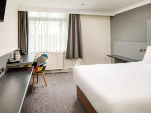 a hotel room with a bed and a desk at Mercure Chester Abbots Well Hotel in Chester