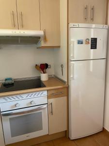 a kitchen with a white refrigerator and a stove at casa Maracujá in Majanicho +10 photos