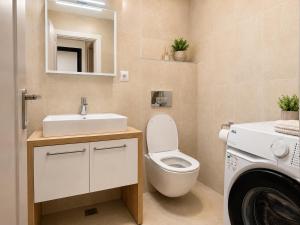 a bathroom with a toilet and a sink and a washing machine at Spacious 3-Room Apartment - NEW Building in Bucharest +18 photos