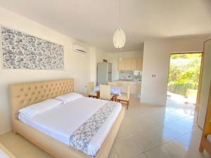 a bedroom with a large bed and a kitchen at APARTAMENT RADHIME in Vlorë