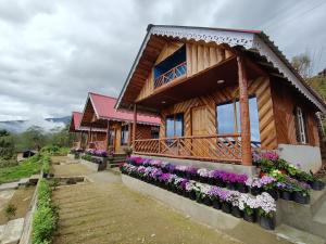 a wooden house with flowers in front of it at Taray Heem Homestay in Ravangla