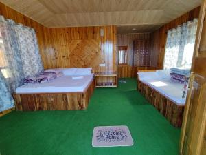two beds in a room with a green floor at Taray Heem Homestay in Ravangla
