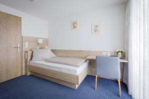 a bedroom with a bed and a desk and a chair at Gasthof Krone Hotel & Restaurant in Friedrichshafen