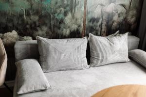 a couch with three pillows on it in a room at GOLDEN HAUS Opole - Black Velvet & Dark Elegance in Opole +32 photos