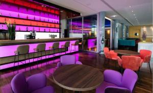 a restaurant with purple lighting and tables and chairs at Windmill Frankfurt Niederrad in Frankfurt +5 photos