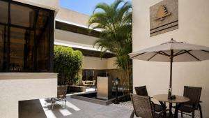 a patio with a table and an umbrella at Cedro Hotel in Londrina