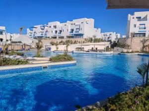 a swimming pool in front of some white buildings at Mountain View Chalet in Ras El Hekma ماونتن ڤيو رأس الحكمة in Ras Elhekma
