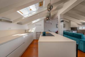an attic kitchen with white cabinets and a blue couch at Villa San Martein in Rovinj