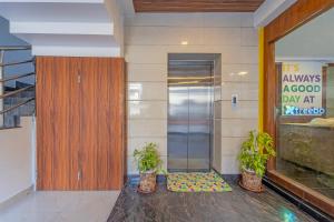 a entrance to a building with two plants in front of a door at Treebo Regalia, Near Medical College & Pattom in Trivandrum