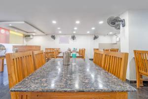 a dining room with a table and wooden chairs at Treebo Regalia, Near Medical College & Pattom in Trivandrum