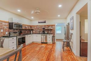 a kitchen with white cabinets and a brick wall at Bluebird Cottage in Roseland
