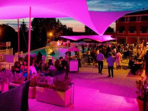 a group of people walking around aestival with purple lights at Mercure Toulouse Aéroport Golf de Seilh in Seilh +115 photos