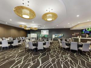 a conference room with tables and chairs and a screen at Mercure Melbourne Caroline Springs in Caroline Springs +112 photos