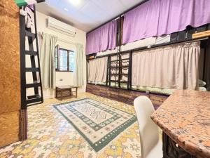 a room with a table and a rug on the floor at Carob Hostel in Amman