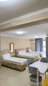 a bedroom with two beds and a table and chairs at Hotel Apart Resilient in Golem +170 photos