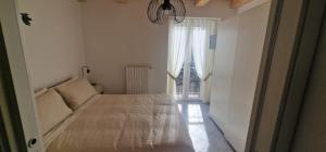 a white bedroom with a bed and a window at Casa Petelia in Serra San Bruno +8 photos