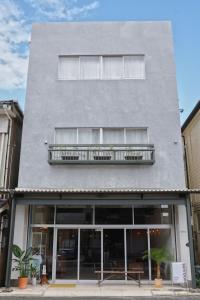 a gray building with a balcony on top of it at sunroom Hotel,Cafe,Bar in Miyazaki