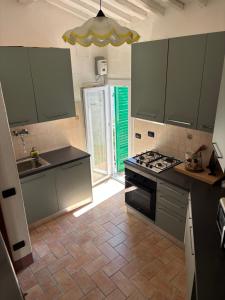 a kitchen with green cabinets and a stove top oven at Dimora Rosé in Crespina