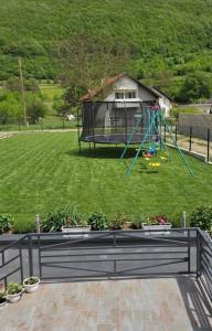 a playground in a park with a swing at Apartments Una Roots in Orašac