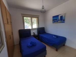 two beds in a room with blue sheets at Sunny coast apartment by the sea in Protaras