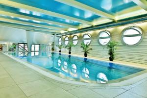 a large indoor swimming pool in a building at Olympia Wellness Hotel in Karlovy Vary