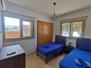 a living room with a blue bed and a chair at Sunny coast apartment by the sea in Protaras +35 photos