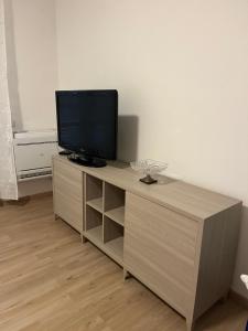 a television sitting on top of a wooden cabinet at Casa Vacanza Giorgio Apartment in Gallarate