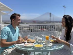 a man and a woman sitting at a table with food at Hotel San Francisco INN in Arequipa