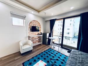 a bedroom with a bed and a chair and a window at Mint Home in Danang