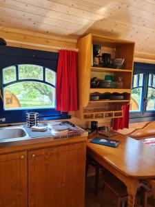 a kitchen with a sink and a wooden table at Hébergements Insolites Camping la Pinède des Mées in Les Mées +15 photos