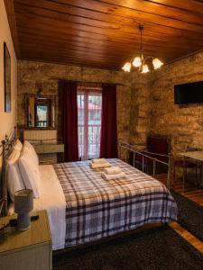 a bedroom with a large bed in a stone wall at Village Inn in Ano Chora