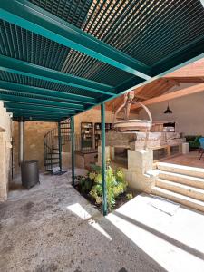 a green pergola with a bench and a table at Le Moulin de Tiquetorte in Moulis-en-Médoc