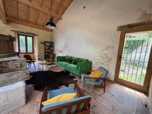 a living room with a green couch and chairs at Le Moulin de Tiquetorte in Moulis-en-Médoc