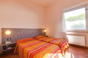 two beds in a room with a window at Autohotel Venezia in Mirano