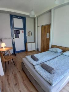 a bedroom with two beds and a table and a door at Pokoje w Centrum - Parking - Rowery in Sopot