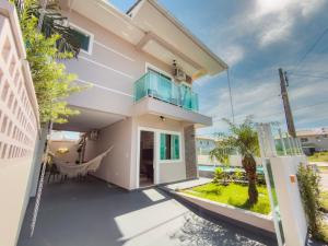a house with a balcony with a hammock at Solar Primavera in Palhoça