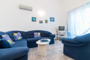 a living room with blue couches and a table at Apartments Bavaria in Baška