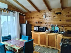 a kitchen with a table and a refrigerator at Cabañas miranda in Quellón