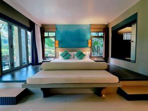 a bedroom with two beds and two windows at Mercure Koh Chang Hideaway in Ko Chang