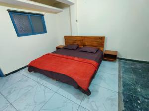 a bedroom with a large bed with a red blanket at Leela's Abode in Bhowāli