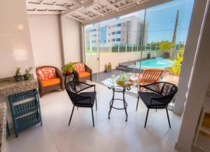 a patio with a table and chairs and a pool at Solar Primavera in Palhoça