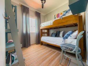 a bedroom with two bunk beds and a chair at Solar Primavera in Palhoça +18 photos
