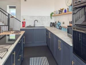 a kitchen with blue cabinets and a sink at Nautilus Cottage in Cellardyke