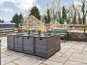 a patio with two tables and a bench in a yard at Peacock Cottage - Uk36422 in Talybont