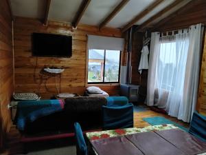 a living room with a couch and a television at Cabañas miranda in Quellón