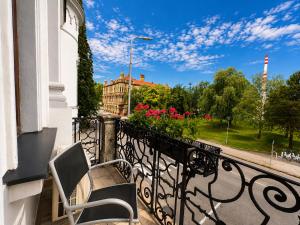 a balcony with a bench and flowers on a building at Olymp penzion in Komárno