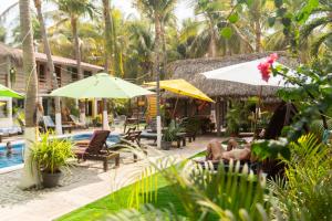 a resort with chairs and umbrellas and a swimming pool at Hotel Frida Paradise in Brisas de Zicatela