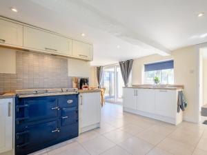 a kitchen with blue and white cabinets and a sink at Rathlin Cottage in Cambridge +13 photos
